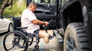 A man with an amputation injury putting on a prosthetic before getting in his truck