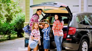 Family getting ready for a road trip behind their vehicle