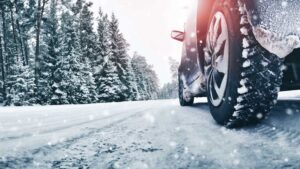 Image of a vehicle driving down a snowy country road with winter tires.