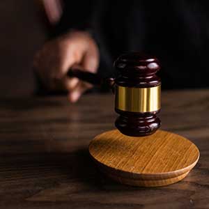 A photo of a judge's hand banging a gavel
