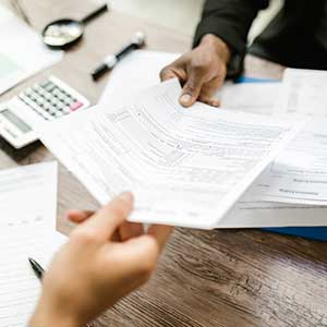 A lawyer sharing insurance documents with a client over a desk.