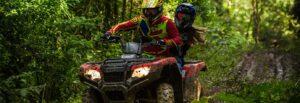 Man and woman atving on a muddy back road in the woods