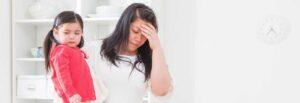 Woman holding her child in her arms feeling stressed due to loss of income benefits