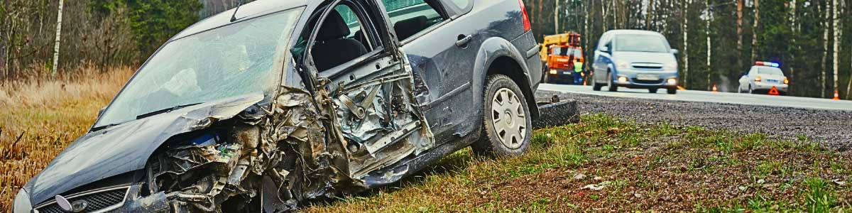 Car on the side of the road with damages from a side swipe accident