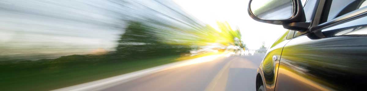 A car speeding down a road with a motion blur.