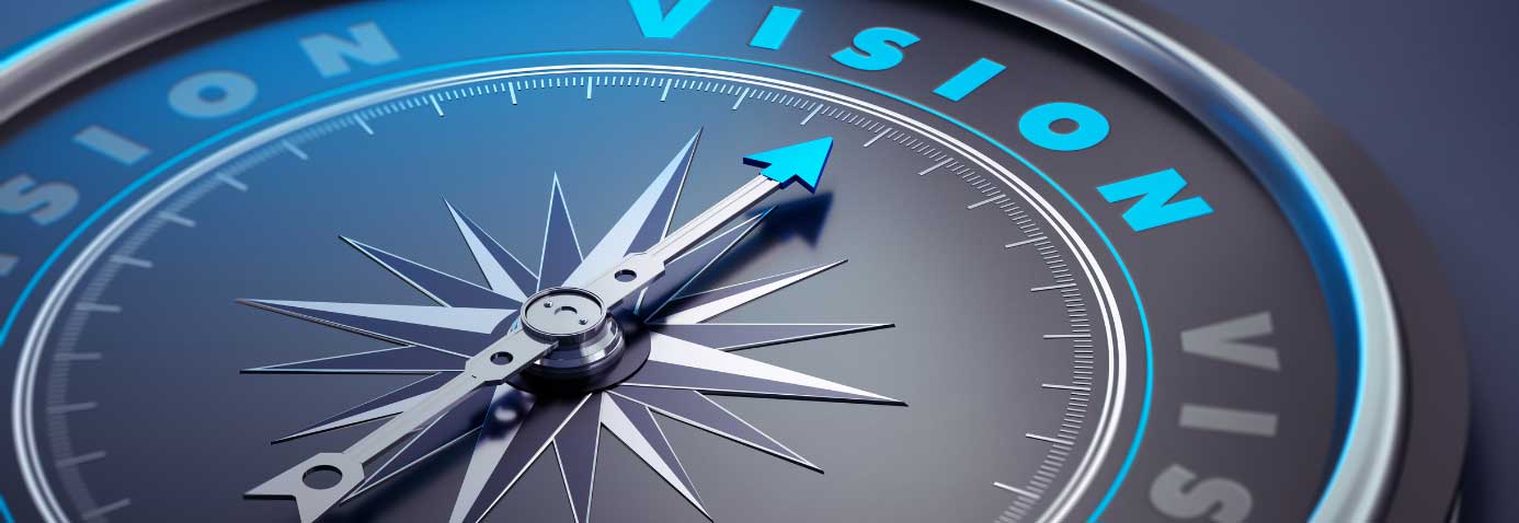 A compass with the needle pointing towards the word vision