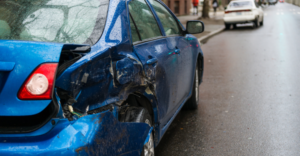 A car that has been a part of a hit and run accident parked on the side of the road