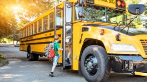 Children loading on a school bus on a beautiful September day