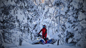 Image of a Snowmobiler in the woods driving a Polaris snowmobile that is subject to a recent recall or stop ride.