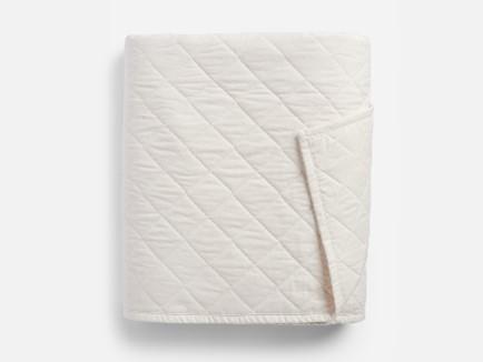 a white blanket folded on a white surface