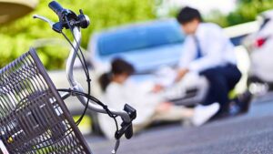 A bicycle on its side with a cyclist blurred in the background